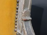 a close up of a yellow chair with a metal ring on it