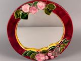 a red mirror with flowers and leaves on it