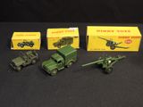 several toy army vehicles are lined up on a black surface