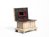 a small wooden box with a red lid on a stand