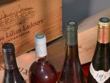 several bottles of wine are lined up on a table next to a wooden box