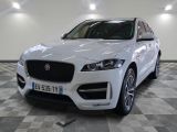 the front view of a white jaguar car in a showroom
