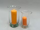 deux vases en verre contenant des bougies, posés sur une table