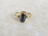 une bague en or avec une pierre noire au centre