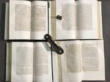 several open books on a table with a pair of scissors on top of them