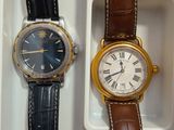 two watches are sitting in a white box on a table