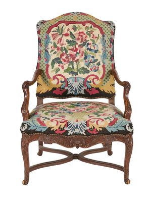 une vieille chaise avec un coussin rembourré aux couleurs vives et une structure en bois