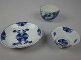 three pieces of blue and white porcelain dishes and cups on a table