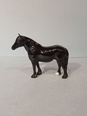 figurine représentant un cheval noir debout sur une surface blanche