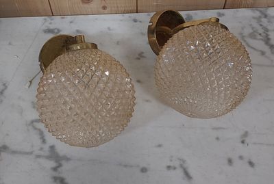 two glass lamps sitting on a marble counter top