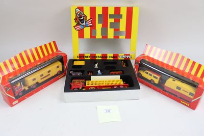 Trois trains miniatures emballés sont posés dans une boîte, sur une surface blanche.