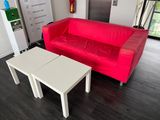 a red couch and a white table in a living room