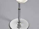 a white stool sitting on top of a metal stand