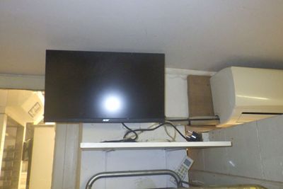 a flat screen tv mounted on a wall above a stove