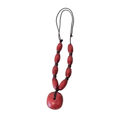 a close up of a red necklace on a white background