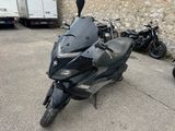 une moto noire garée devant un mur de pierre