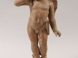 an old statue of a cupid holding a flower on a pedestal