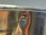 a reflection of a person in a mirror on the side of a metal object