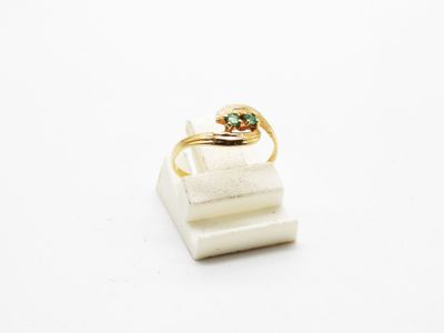 a close up of a gold ring with a green stone