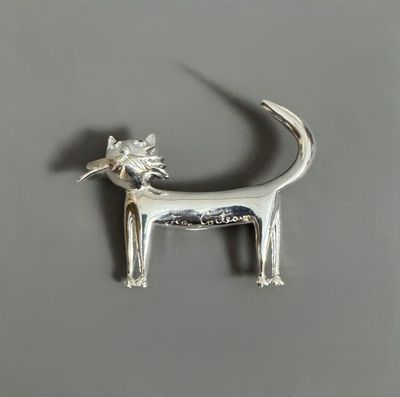 silver dog broochle with a flower on it ' s head