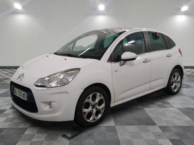 the small white car is parked on a checkered tile floor