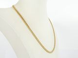 a gold chain necklace on a mannequin torso