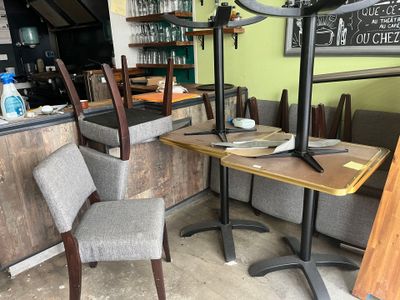 a table and chairs in a restaurant with a clock on the wall