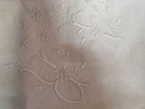 a close up of a white table cloth with embroidered flowers on it