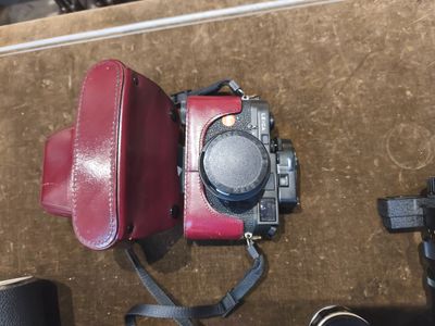 un appareil photo rouge et un sac rouge posés sur une table