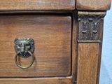 a wooden dresser with a lion ' s head on it