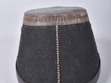 a black hat with a chain around it on a white surface