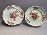deux assiettes avec des fleurs peintes dessus, posées sur une table