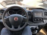 a man sitting in the driver ' s seat of a car