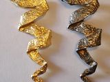 trois morceaux de feuille d'or et d'argent sur un fond blanc