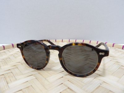 un gros plan sur une paire de lunettes de soleil posée sur un panier tressé