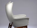 an image of a white leather chair with wooden legs