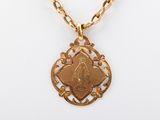 une photo d'un collier en or sur lequel figure le portrait d'une femme