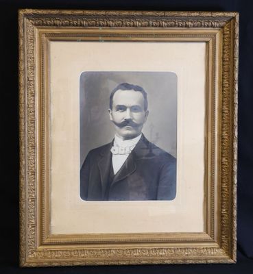 an old picture of a man with a mustache in a gold frame