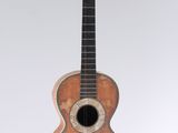 a small wooden guitar with a hole in the neck
