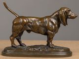 bronze statue of a dog standing on a base on a table