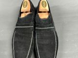a close up of a pair of black sued shoes on a gray surface