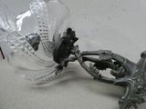 a glass vase with a bird on it and a bird on a branch