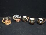 six ceramic mugs with different designs on them sitting on a black surface