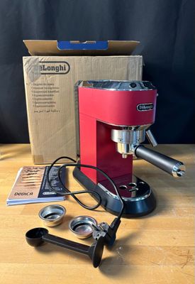 une machine à café rouge posée sur une table à côté d'une boîte