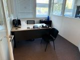 un bureau avec un ordinateur et une chaise dans une pièce