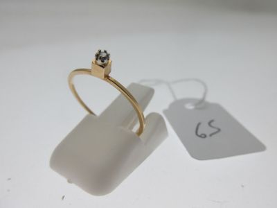 une bague en or ornée d'un diamant et d'une étiquette de prix