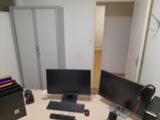 a computer desk with two monitors and a keyboard on it