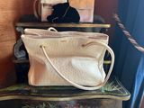 a white purse sitting on top of a wooden table