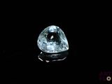 gros plan d'un diamant bleu sur une surface noire