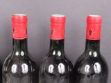 three bottles of wine are lined up on a table